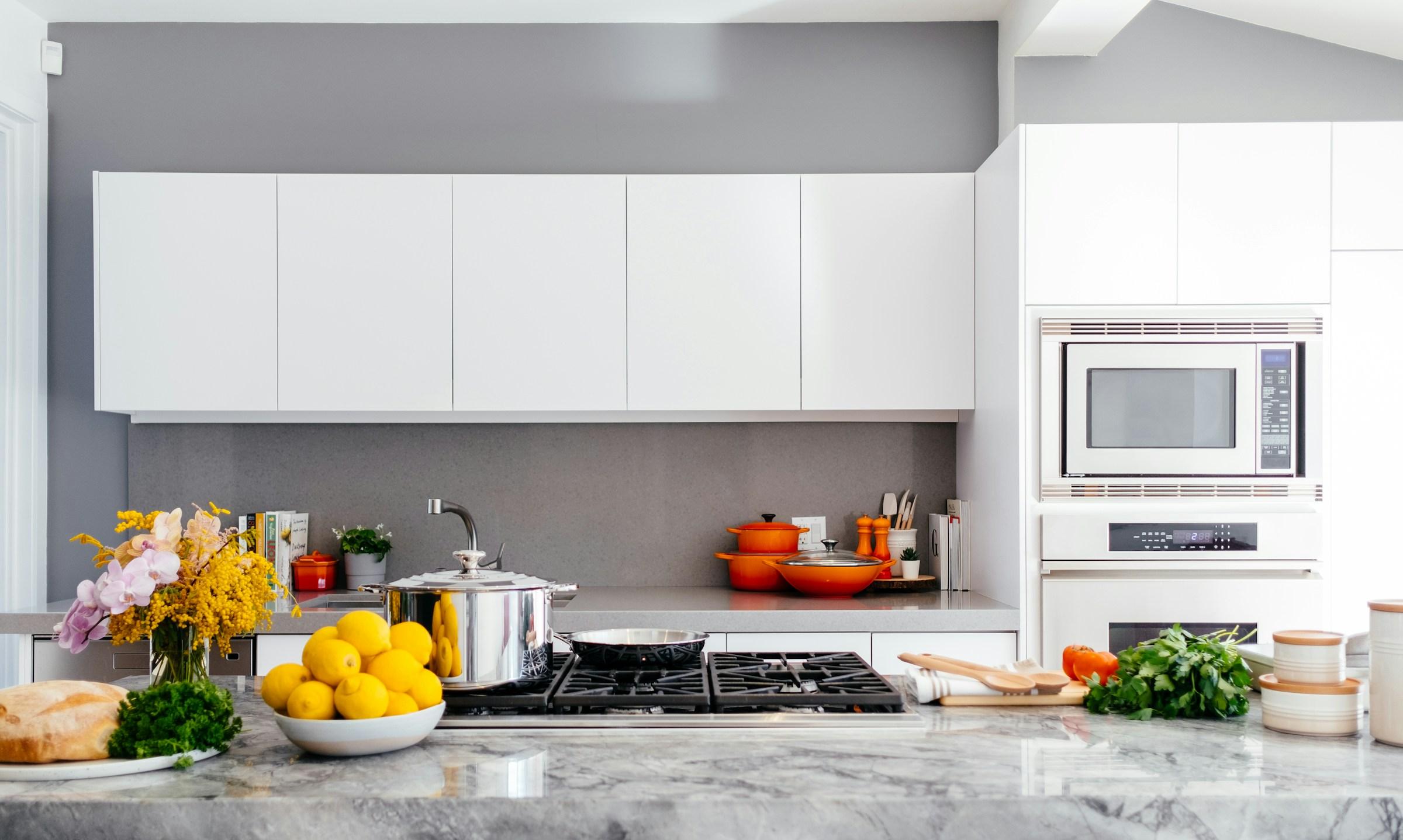 Modern fitted kitchen with white cabinets, island and integrated appliances